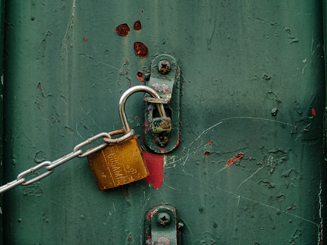 Porte verte avec un cadenas et une chaîne. Service de serrurerie pour bloqué dehors serrure cassée Lille.