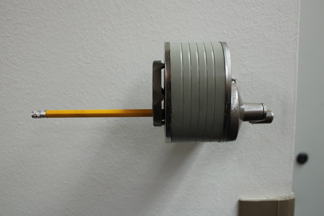 Crayon tenu avec précision dans un dispositif mécanique, illustrant notre expertise en dépannage volet roulant Villeneuve d'A